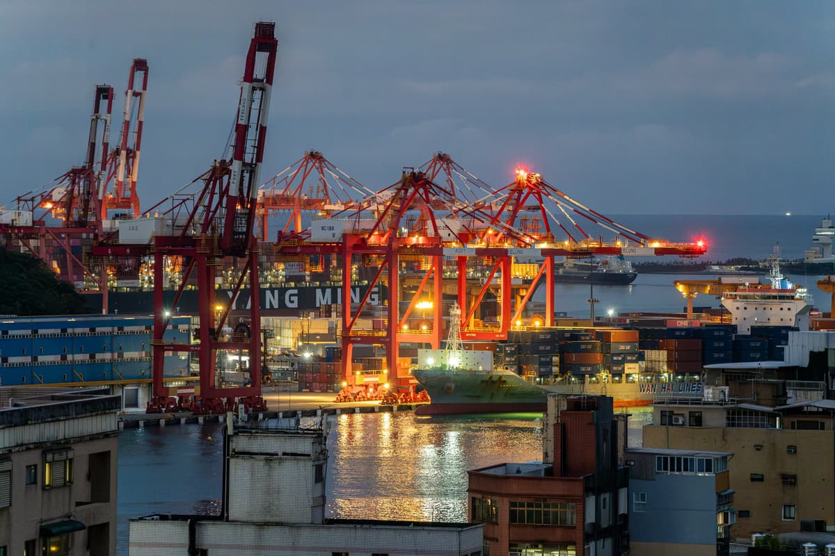 Container port with gantry cranes lit up at dusk